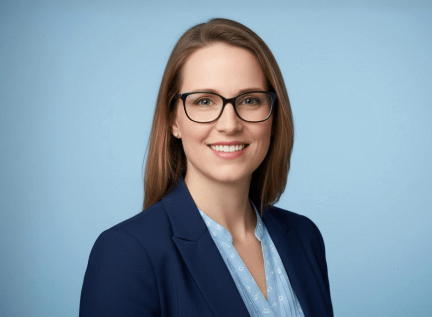 A linkedin photo of a smiling female teacher with glasses