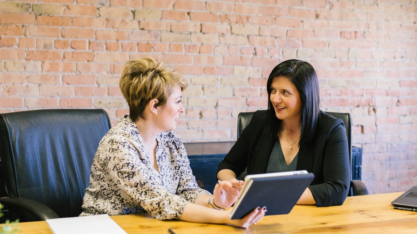 Two female marketers discuss the creation of product advertisements