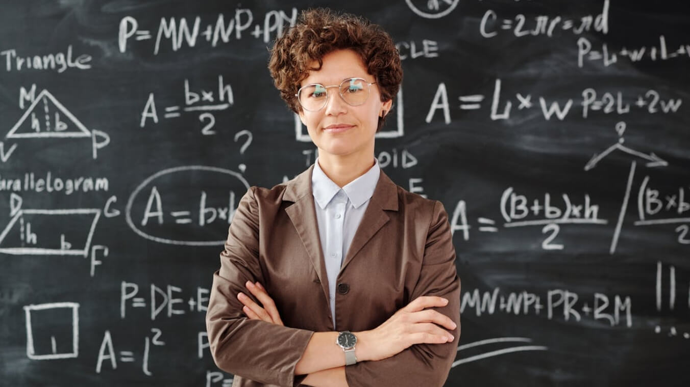 Uma mulher em pé na frente do quadro negro